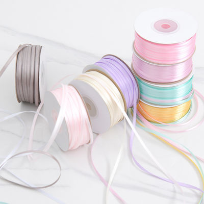 3 มิลลิเมตร สีแคบหลากหลาย สีที่กําหนดเอง ความทนทานสูง พอลิเอสเตอร์ เซตินริบบอนสําหรับการบรรจุของขวัญ