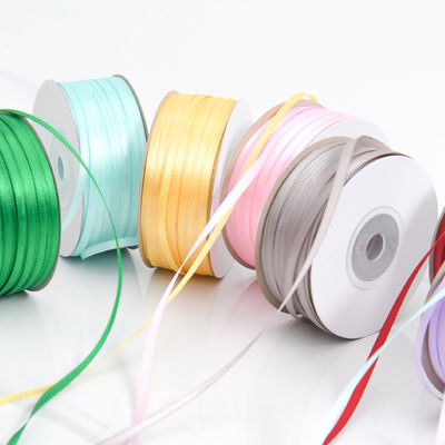 3 มิลลิเมตร สีแคบหลากหลาย สีที่กําหนดเอง ความทนทานสูง พอลิเอสเตอร์ เซตินริบบอนสําหรับการบรรจุของขวัญ